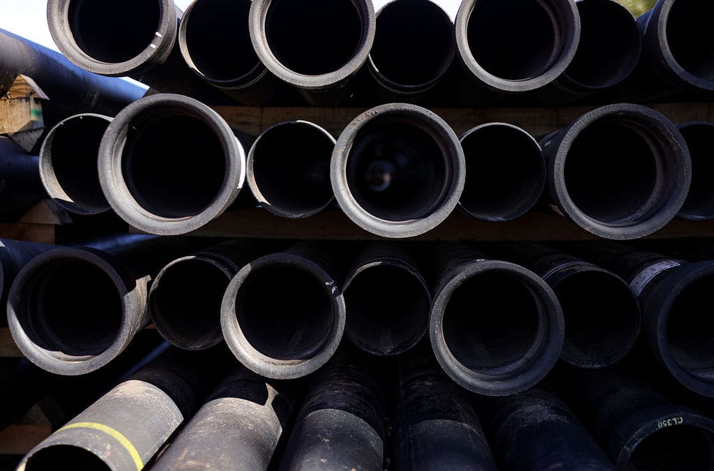 A collection of building materials (pipes) stacked on a construction site.